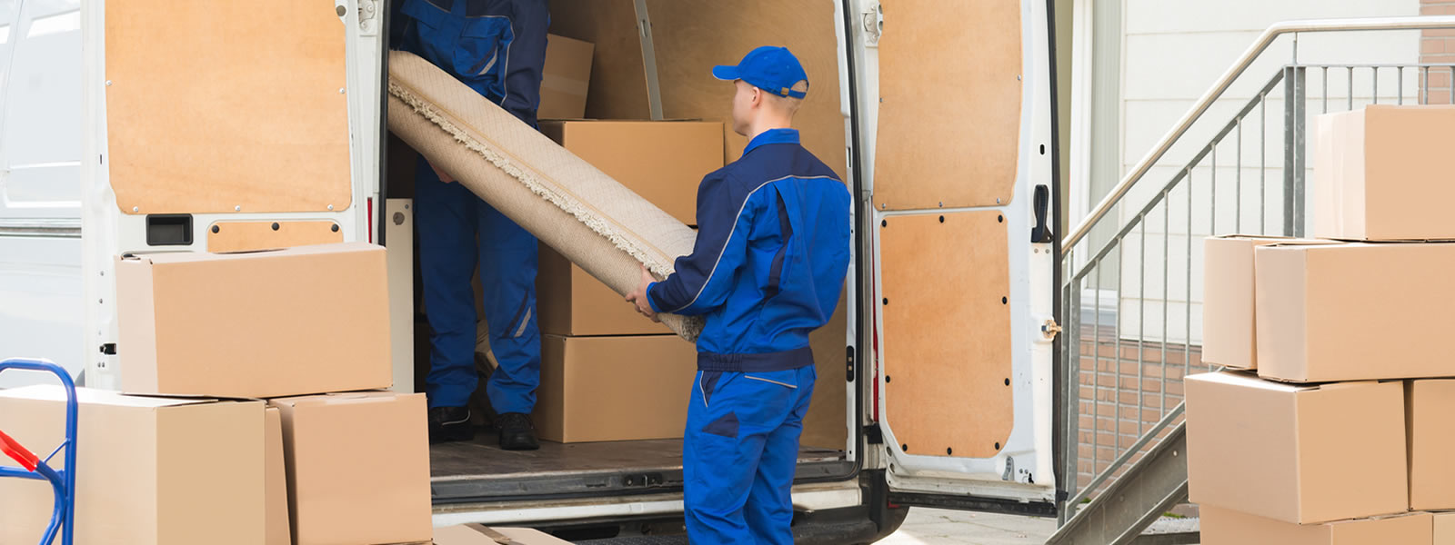 A man assisting with company relocation by loading boxes into a moving truck.