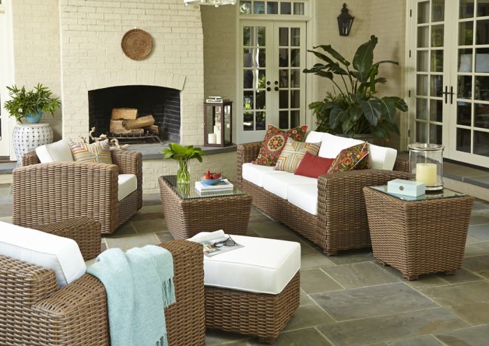 A patio decorated with a wicker furniture set.