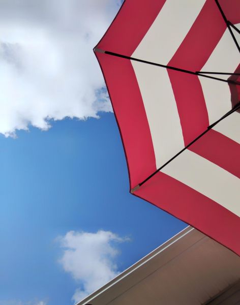 A decorative red and white striped umbrella to enhance your patio.