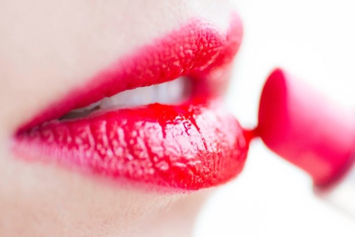 A close up of a woman's lips with red lipstick.