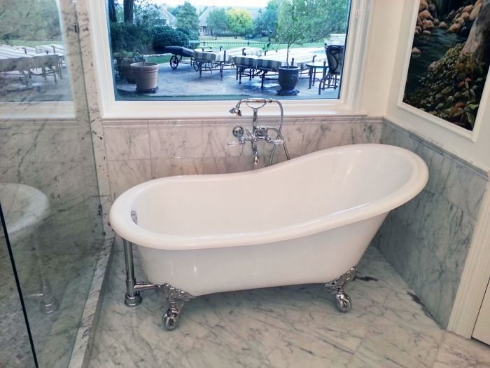 A DIY bathroom remodel featuring a white bathtub and window.