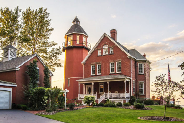 A lighthouse home with a red brick house.