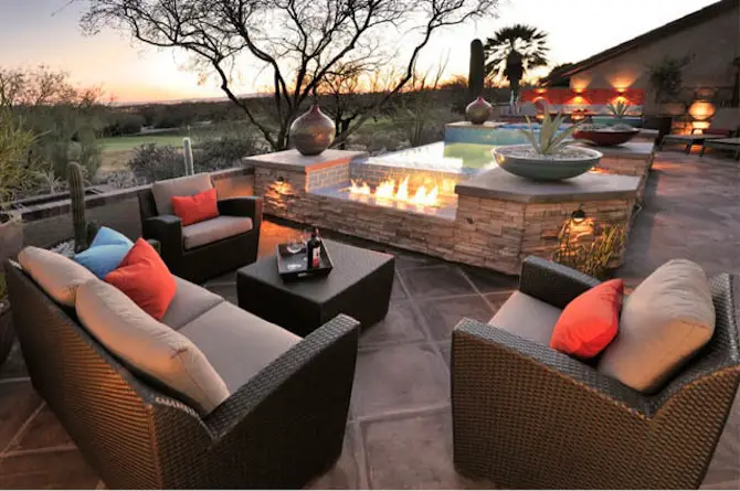 A garden with wicker furniture and a fire pit.
