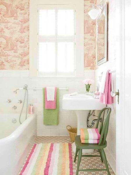Design a bathroom with striped wallpaper and a pink rug.