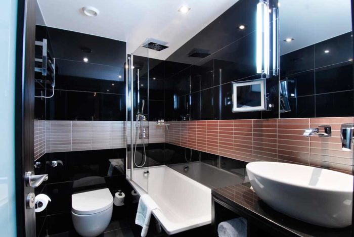 Design a black and white bathroom with a toilet and sink.