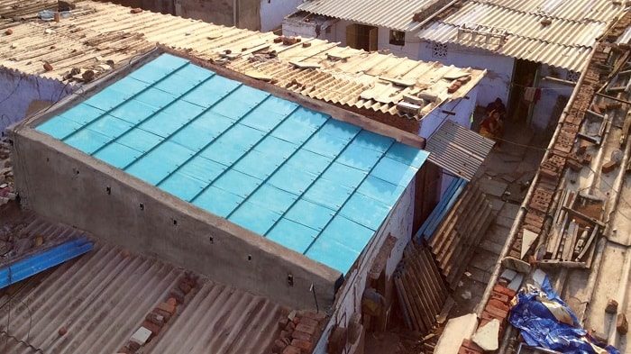 An aerial view of a building with an unconventional blue roof.