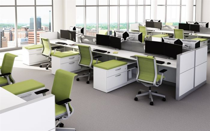 An open office with contemporary green chairs and desks.