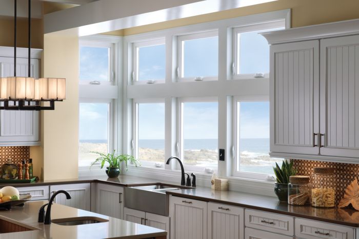 A kitchen with large windows overlooking the ocean and providing ample natural lightning.