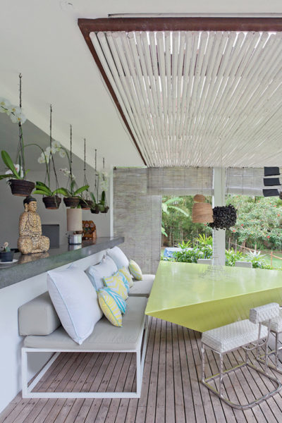 A modern garden patio with a green table and chairs.