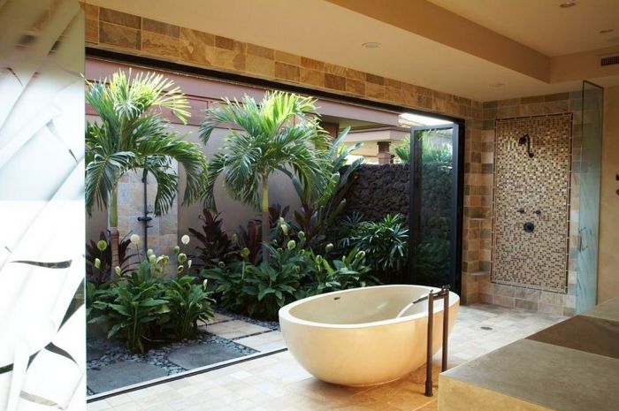 A bathroom with a large tub and an indoor garden view.