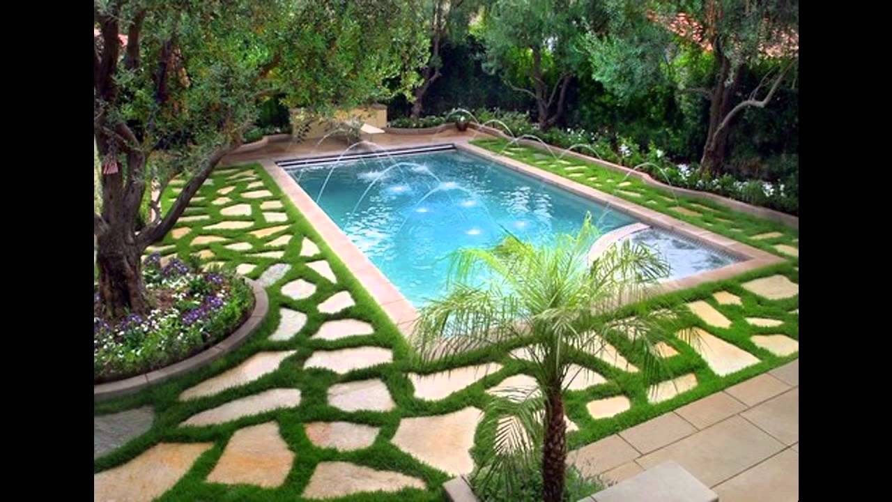An outdoor swimming pool surrounded by grass and trees.
