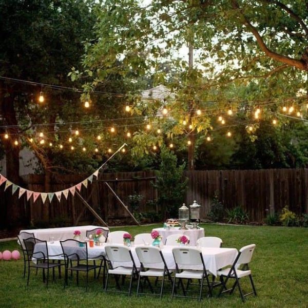 A budget-friendly garden with a table and chairs set up for a party.