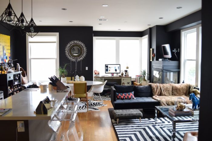 A living room featuring black walls and a zebra rug crafted through interior designing.