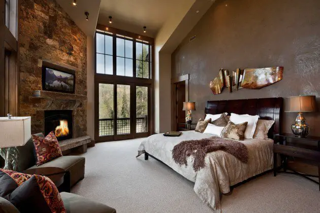 A cozy bedroom with a fireplace and a large bed.