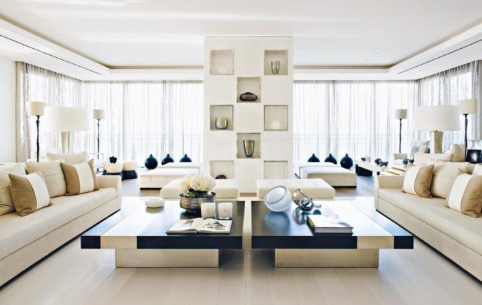 An interior designing of a living room with white furniture and a coffee table.