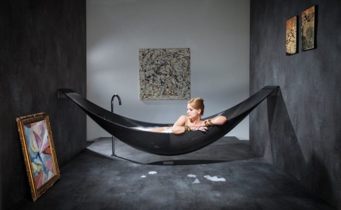A woman lounges in a hammock in a stylish room.