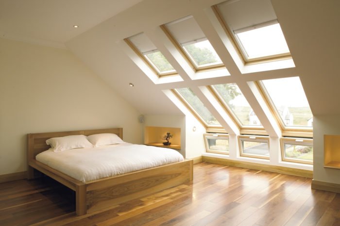 A creative attic bedroom with a bed and a window.