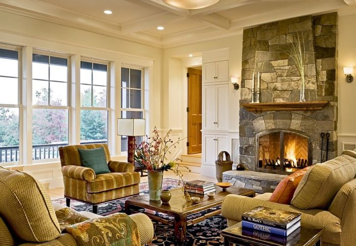 A cozy living room with a stone fireplace and couches.