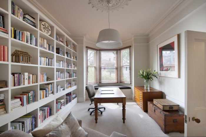 A home office with creative alternatives for book storage and a desk.