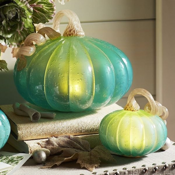 Three fresh green pumpkins on a table.
