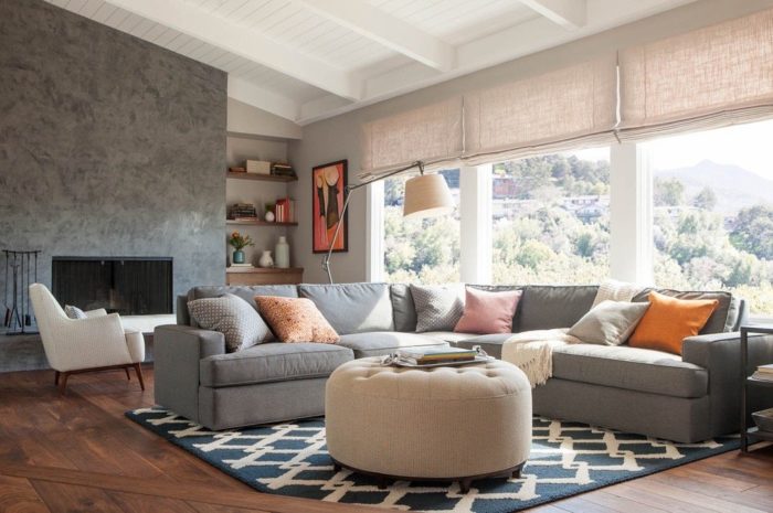 A cozy living room with a grey couch and ottoman.