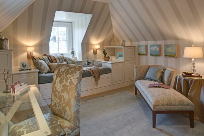 An attic bedroom with cozy spaces and striped walls.