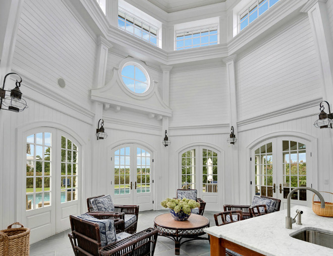 A large living room with a fireplace and large windows in a lighthouse home.