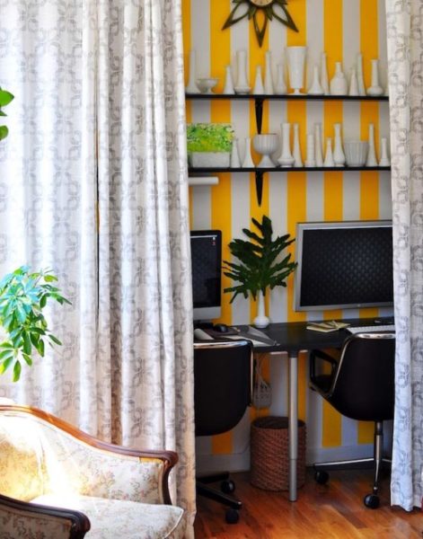 A home office with a creative yellow and white striped wall.