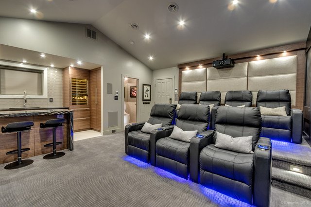 A creative alternative for a home theater room with a bar and chairs.