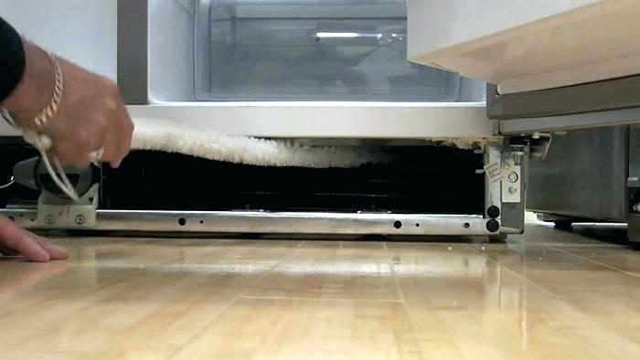A person performing home maintenance inside a refrigerator.