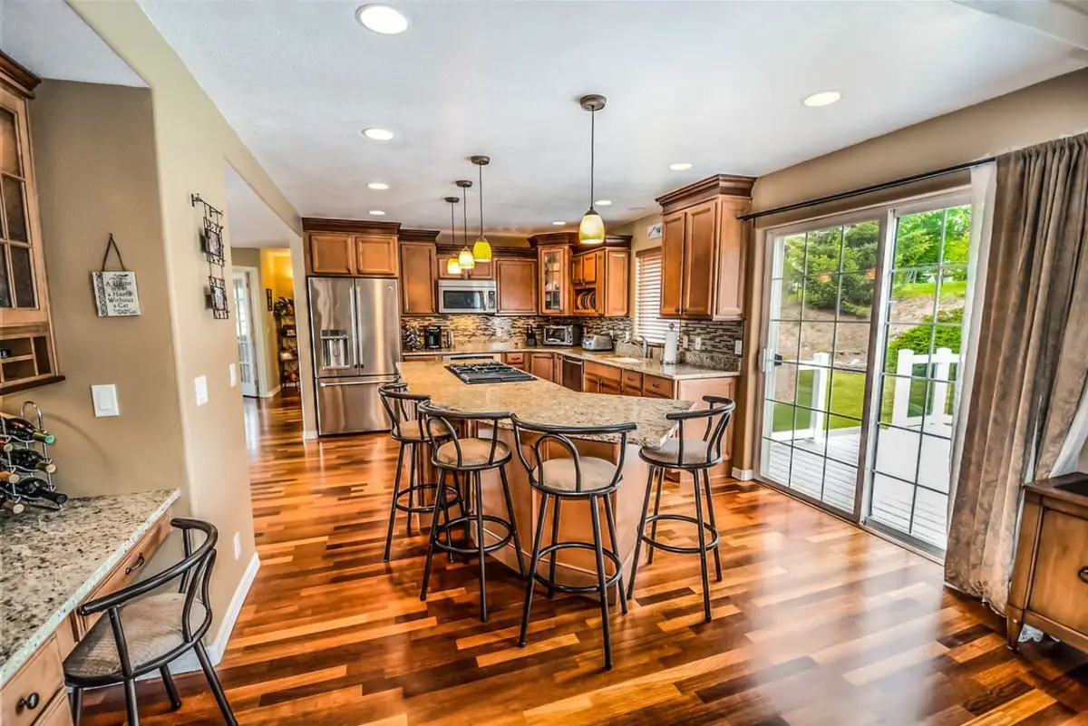 Modern kitchen interior with hardwood floors and granite counters.