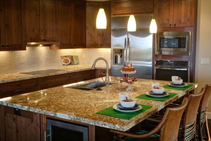 A kitchen with granite counter tops and stainless steel appliances featuring kitchen islands.