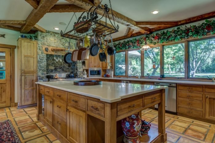A kitchen with wood beams and a large island for kitchen islands.