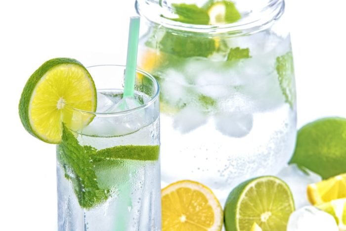A glass of water with refreshing lemons and limes.