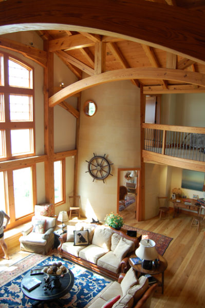 A spacious living room with wood beams in a lighthouse home.