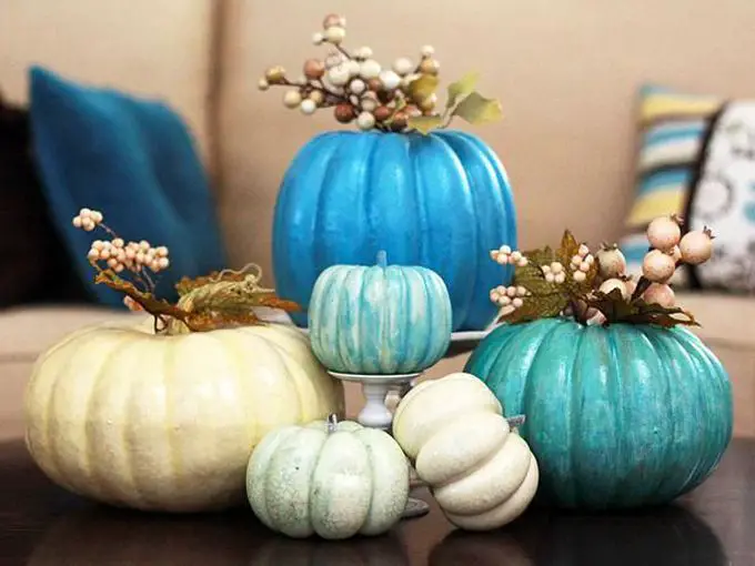 A fresh fall decorating display featuring blue and white pumpkins on a table.
