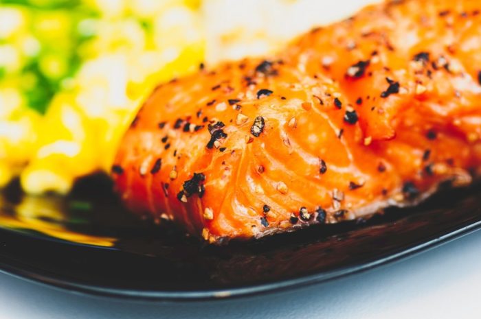 A plate with salmon and corn on it, promoting glowing skin.