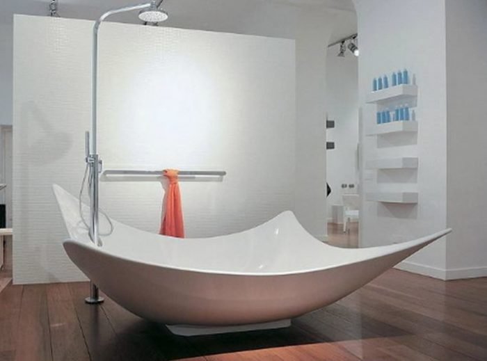 A stylish white bathtub in a bathroom with wooden floors.