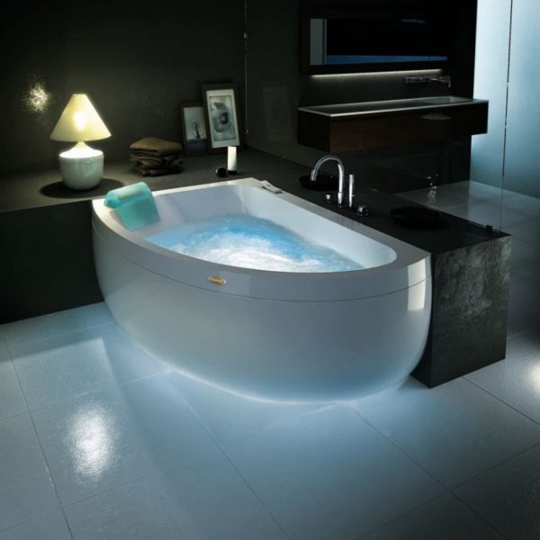 A stylish bathtub with a light in a bathroom.