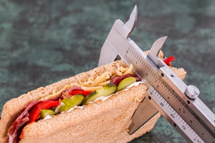 A sandwich is being measured to help lose weight.