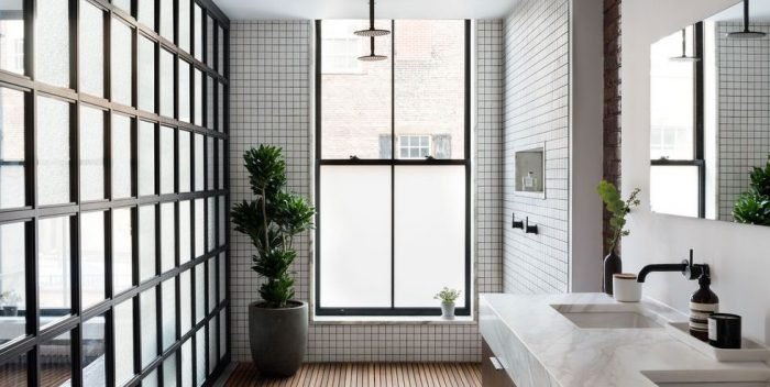 A bathroom with large windows and a sink featuring small bathroom ideas.
