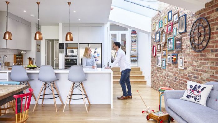 A kitchen with a brick wall and a table and chairs undergoes a realistic home makeover.
