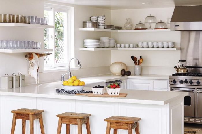 A vintage kitchen with stools and shelves.