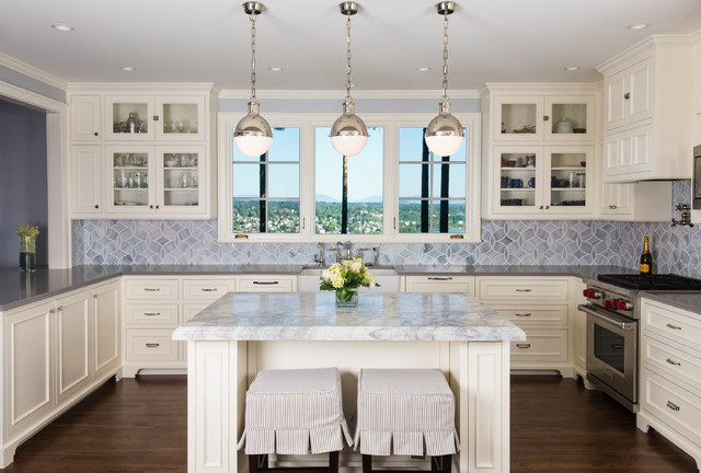 A vintage kitchen with marble counter tops and a center island.