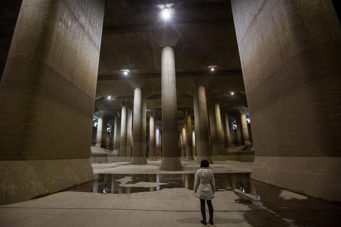 A person standing in the middle of a large concrete structure, highlighting its impressive size.