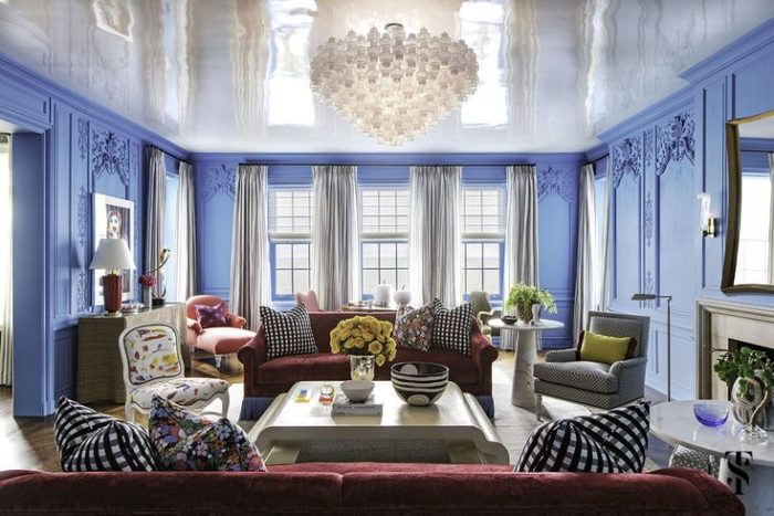 A living room designed by Summer Thornton with blue walls and a chandelier.