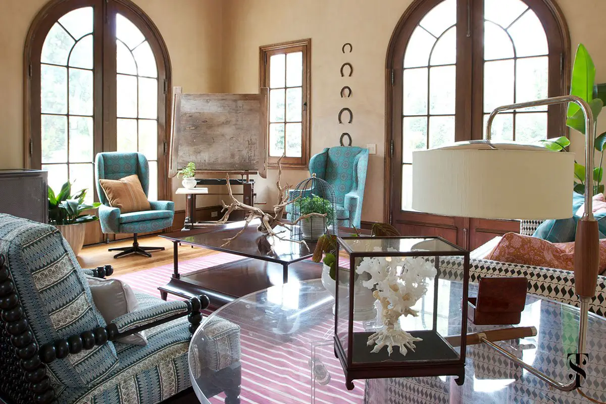 Elegant living room with large arched windows and eclectic decor.