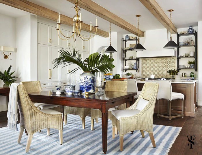 A blue and white striped rug in a dining room designed by Summer Thornton.