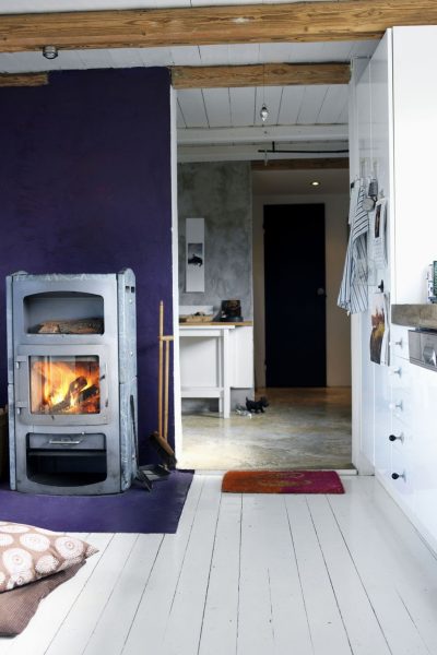 Small white kitchen with a wood burning stove.