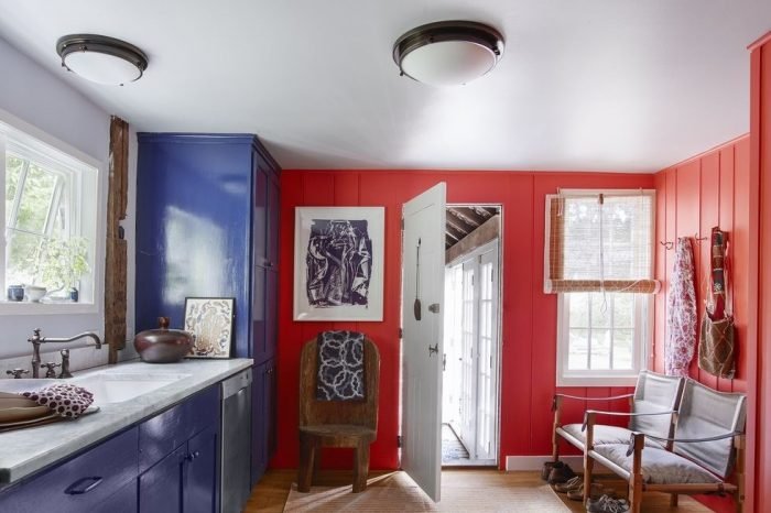 A small kitchen with blue and red walls and a sink.